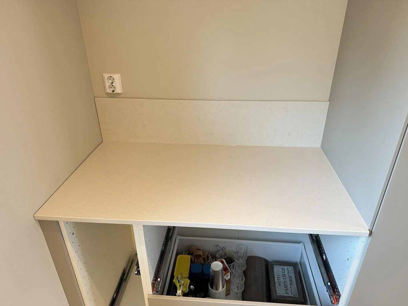 Ovanifrån av polerad Silestone Linen Cream köksbänkskiva med uppvikt stänkkant i ett kök i Växjö.