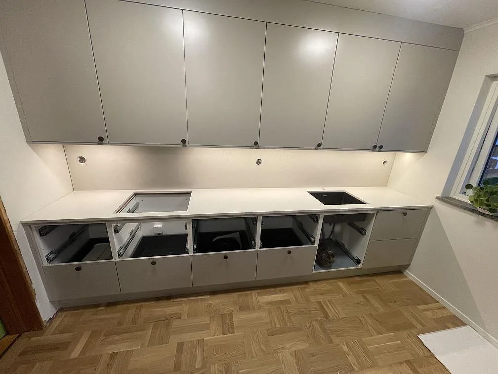 Köksbänkskiva i polerad Silestone Linen Cream med stänkskydd, hällurtag och diskhourtag i ett kök under montering i Valbo.