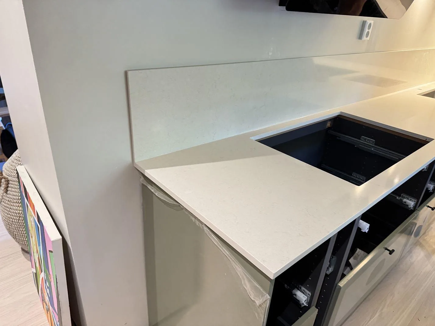 Köksbänkskiva i polerad Silestone Linen Cream, 20 mm komposit, med urtag för häll och låg stänkkant i ett kök i Veberöd.