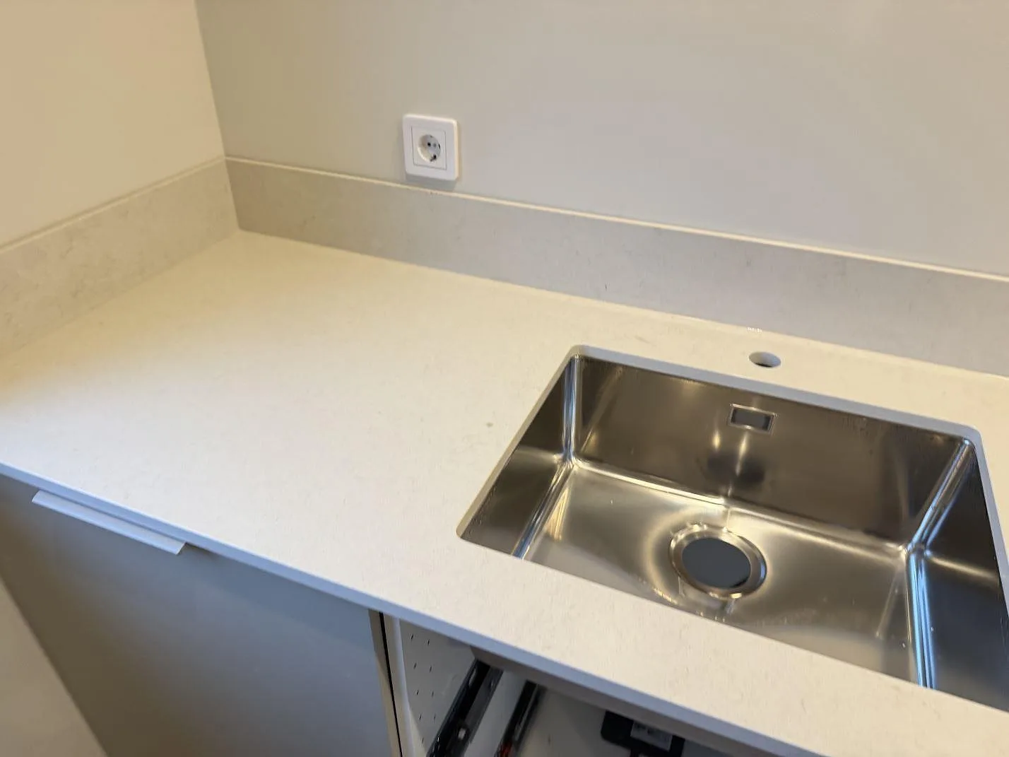Polerad Silestone Linen Cream som köksbänkskiva med underlimmad rostfri diskho, blandarhål och låg stänkkant i Vintrie.