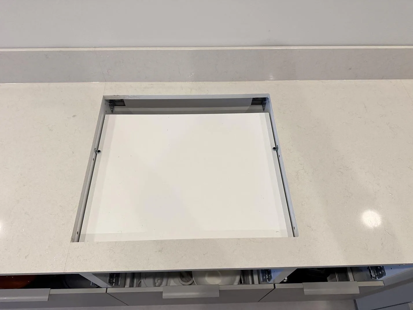 Urtag för häll i polerad Silestone Linen Cream med 12 mm stänkskydd mot väggen i kök i Vintrie.