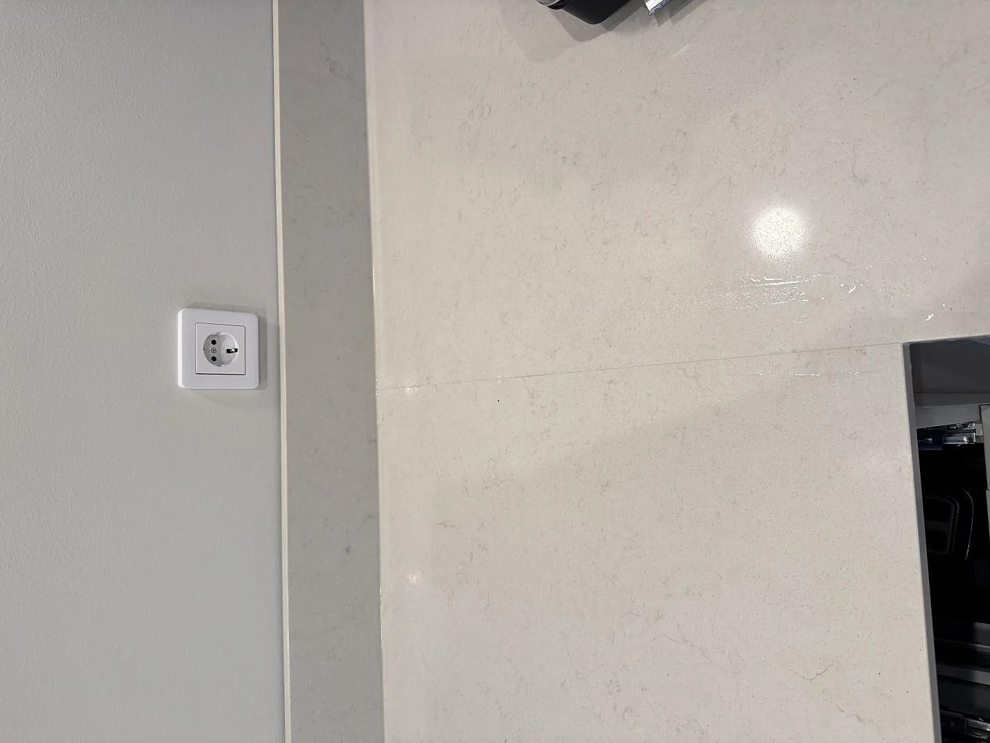 Topvy över ljus polerad Silestone Linen Cream bänkskiva med uppvikt stänkkant och synlig stenådring i Vintrie.