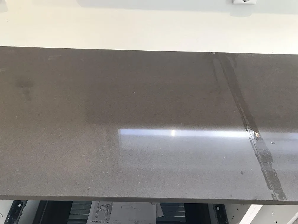 Köksbänkskiva och köksö i mörkgrå Silestone Marengo, polerad kvartskomposit, monterad i ett kök i Nyhamnsläge.