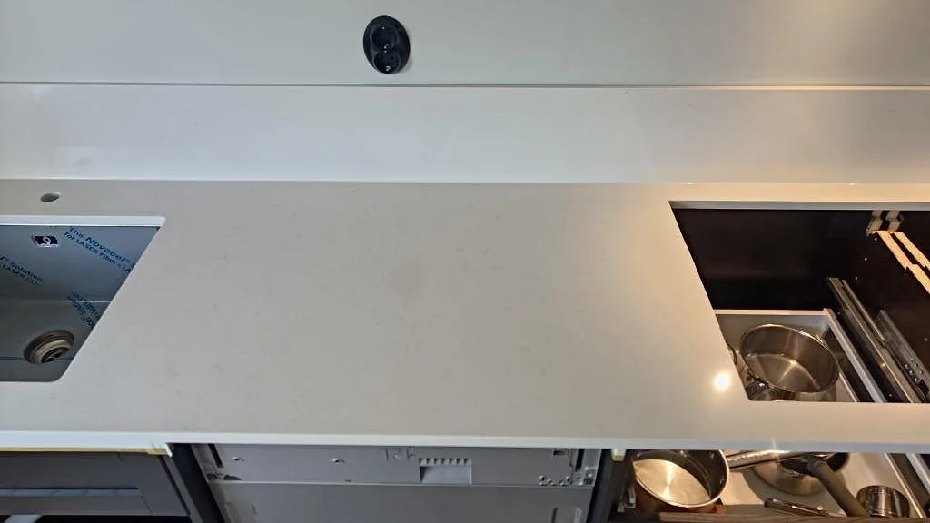 Köksbänkskiva i polerad Silestone Miami Vena med diskho och öppen förvaring under montering i bunkeflostrand.