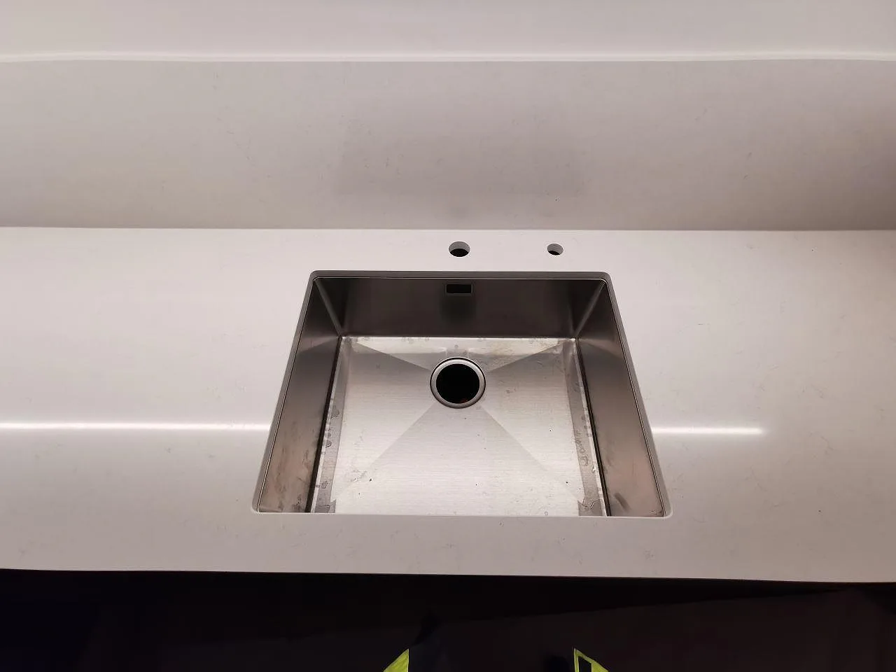 Underlimmad rostfri diskho i polerad Silestone Miami Vena med två blandarehål i ett kök i Göteborg.