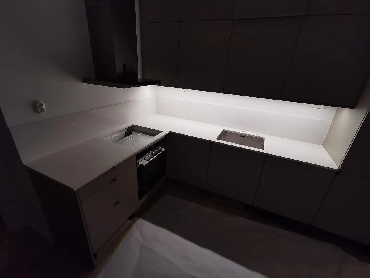 Köksbänkskiva i vit Silestone Miami Vena, polerad, med grå ådring i ett L-format kök med mörkgrå luckor i Göteborg.
