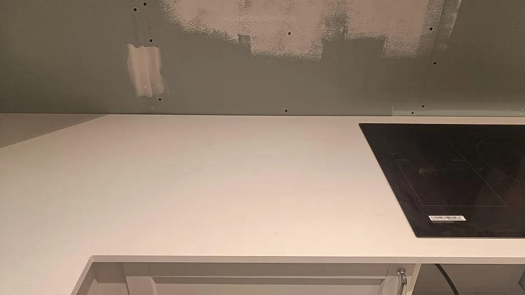 Vit Silestone Miami Vena köksbänkskiva med hällplats och vägganslutning under montering i Höllviken.