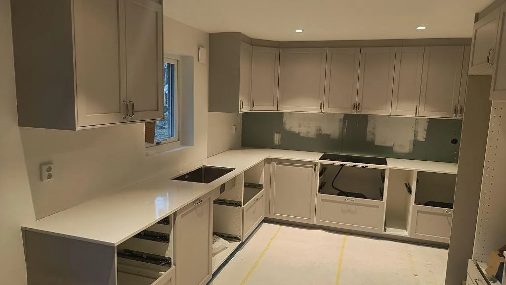 Köksbänkskiva i vit Silestone Miami Vena, polerad, monterad på vita köksstommar i Höllviken.