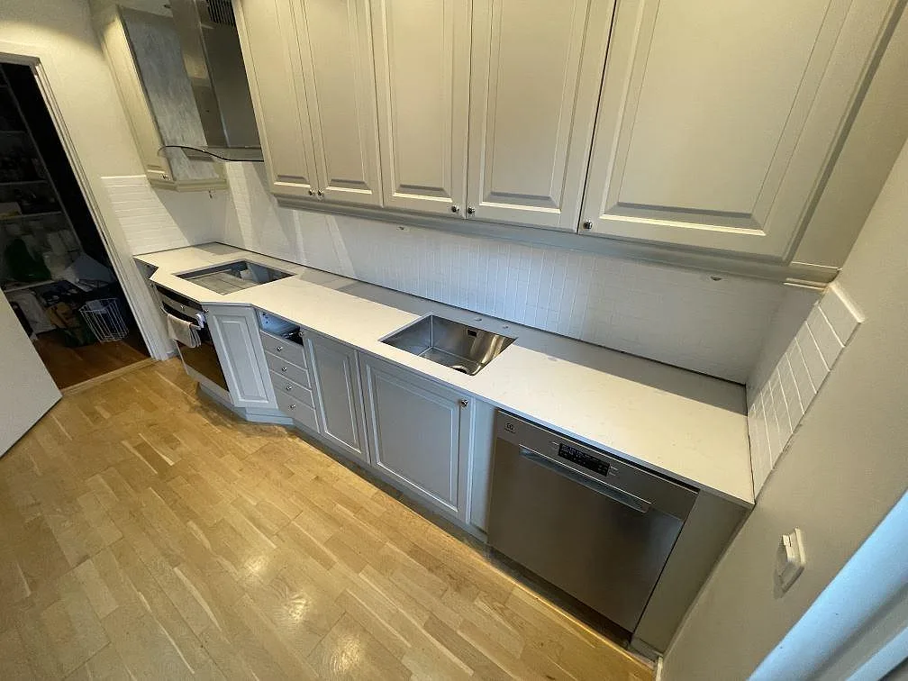 Polerad köksbänkskiva i Silestone Miami Vena med ljus ådring och synlig diskhozon i ett kök i Huddinge.
