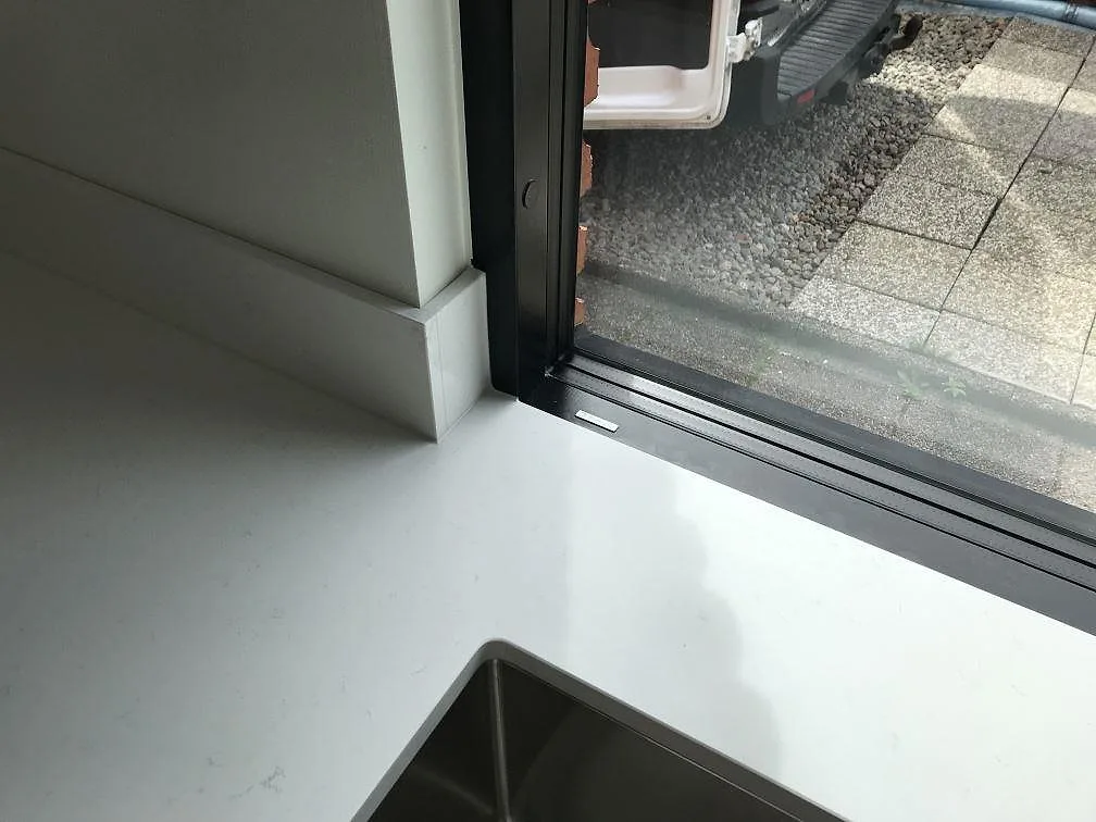 Underlimmad diskho i vit Silestone Miami Vena bänkskiva intill fönsterparti i ett kök i Karlshamn.