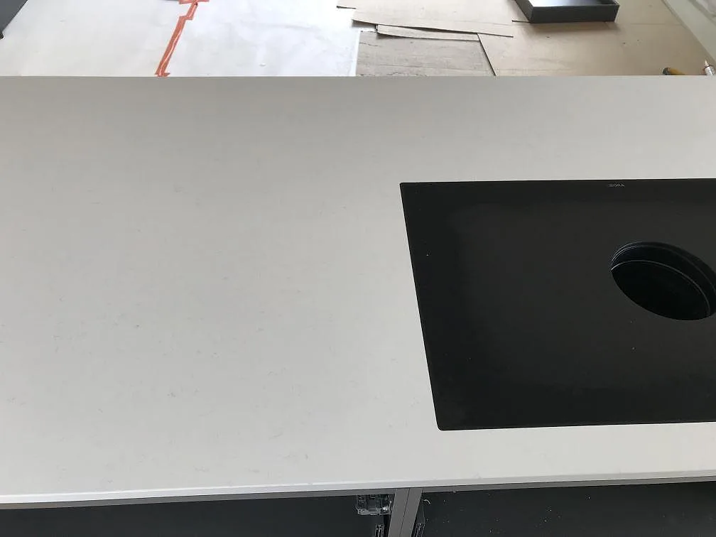 Köksbänkskiva i vit Silestone Miami Vena med urtag och svart downdraft-induktionshäll, kök i Karlshamn.