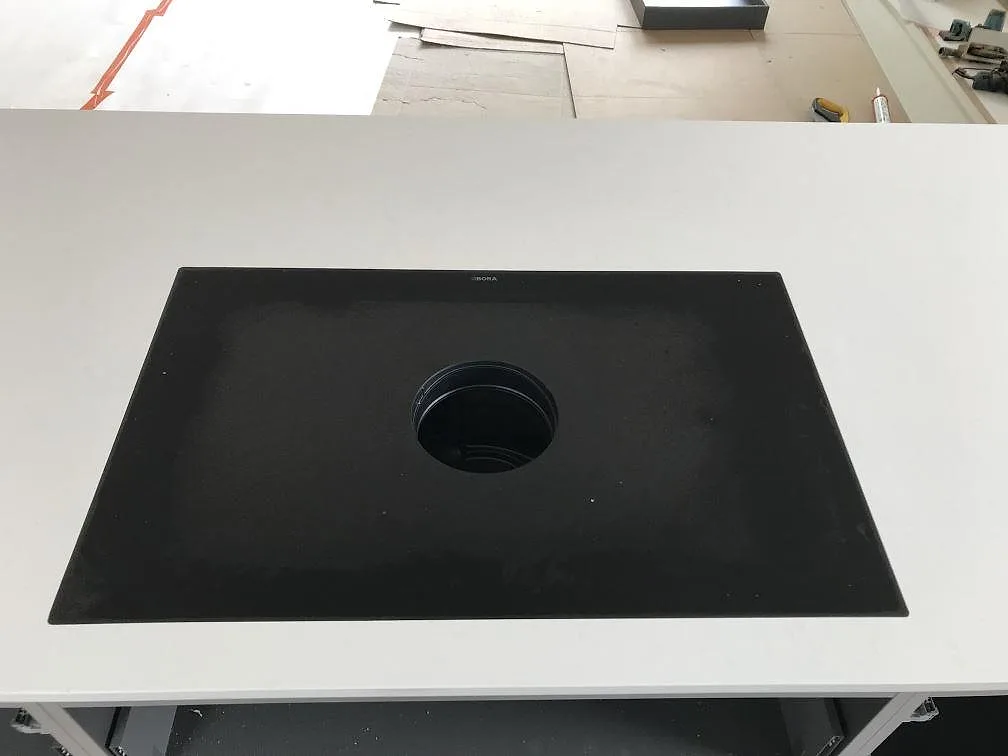 Köksö i vit Silestone Miami Vena med BORA-liknande downdraft-häll sedd uppifrån i ett kök i Karlshamn.