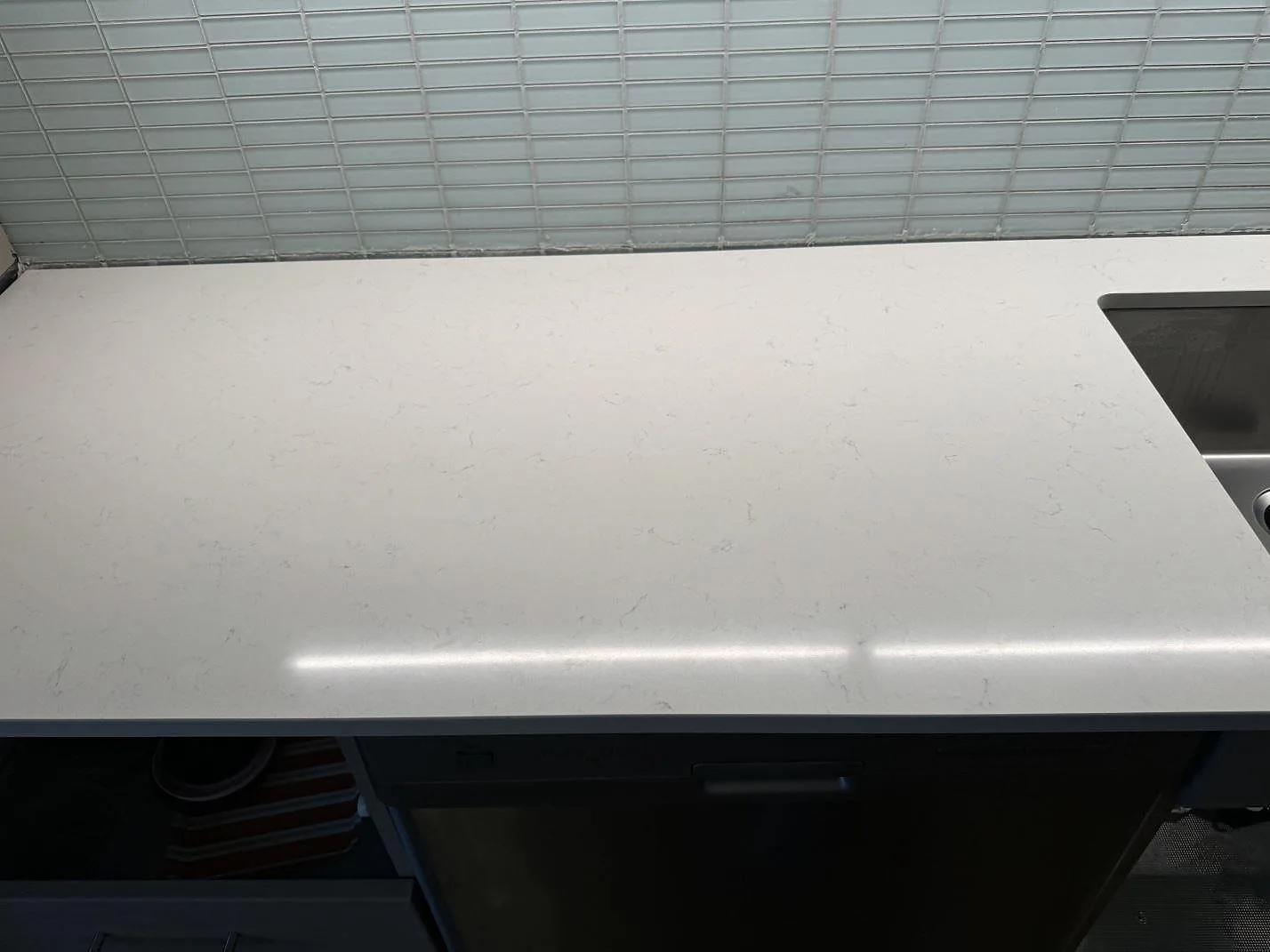Rak vy över köksbänkskiva i polerad Silestone Miami Vena i Malmö, med blank ljus komposityta och diskho i kanten.