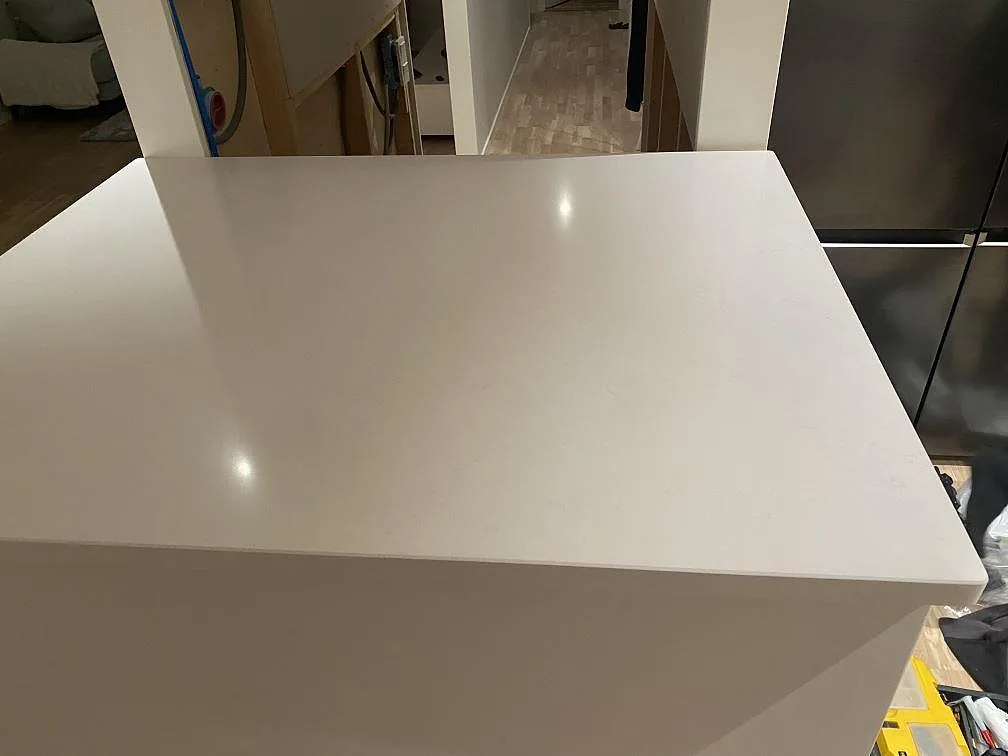 Närbild av köksö i polerad Silestone Miami Vena, ljus kvartskomposit med rak kant i Mariestad.
