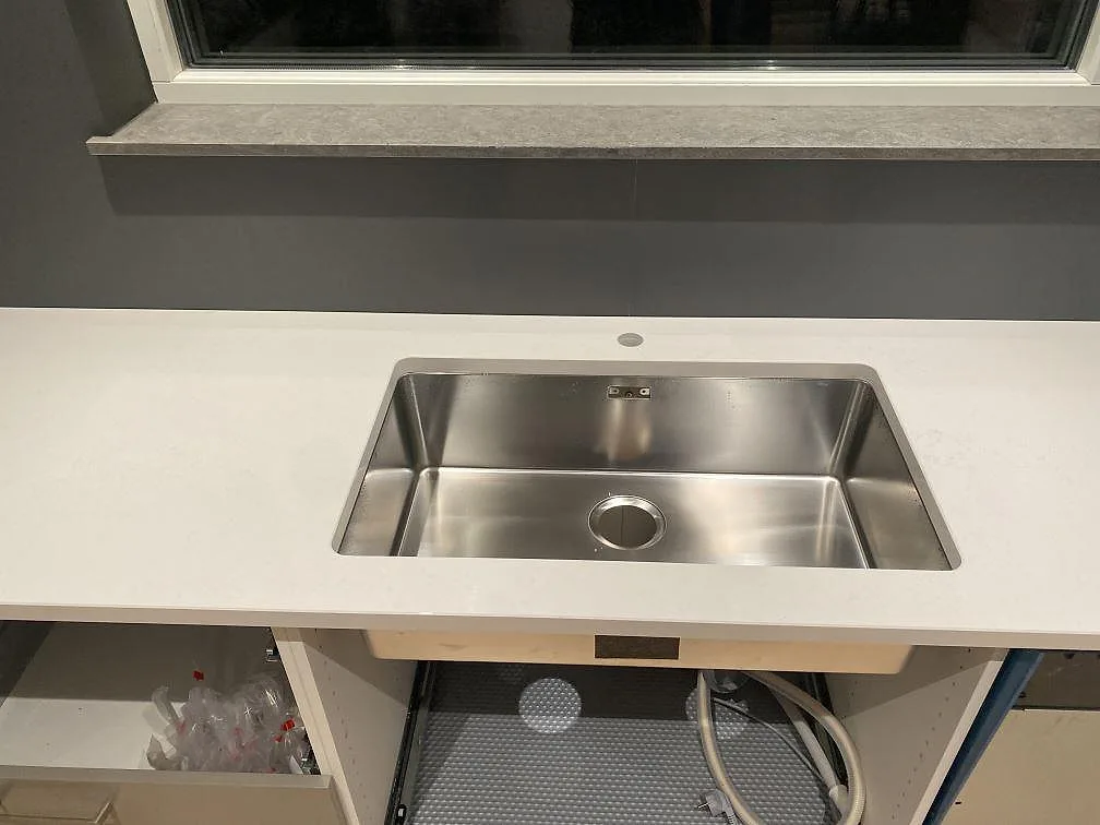 Polerad Silestone Miami Vena som köksbänkskiva med rostfri diskho och ljus sten vid fönster i Mariestad.