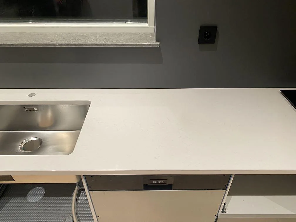 Ljus köksbänkskiva i Silestone Miami Vena, polerad kvartskomposit, med diskho och hällzon i Mariestad.