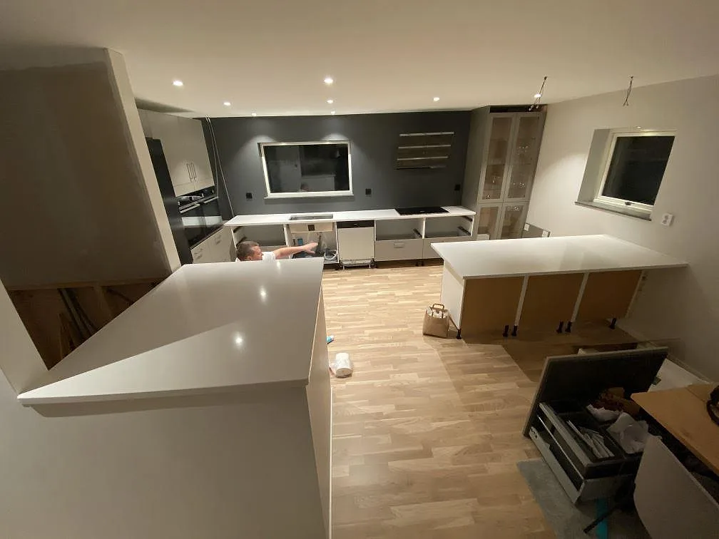 Köksbänkskiva och köksö i polerad Silestone Miami Vena, ljus kvartskomposit, under montering i ett kök i Mariestad.