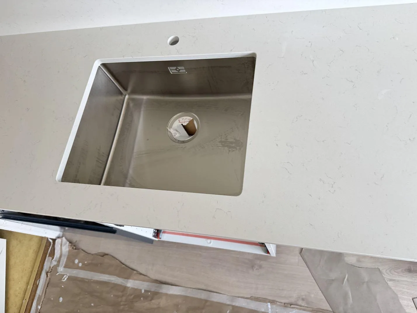 Närbild på underlimmad rostfri diskho i polerad Silestone Miami Vena, vit kvartskomposit med diskret ådring i Staffanstorp.