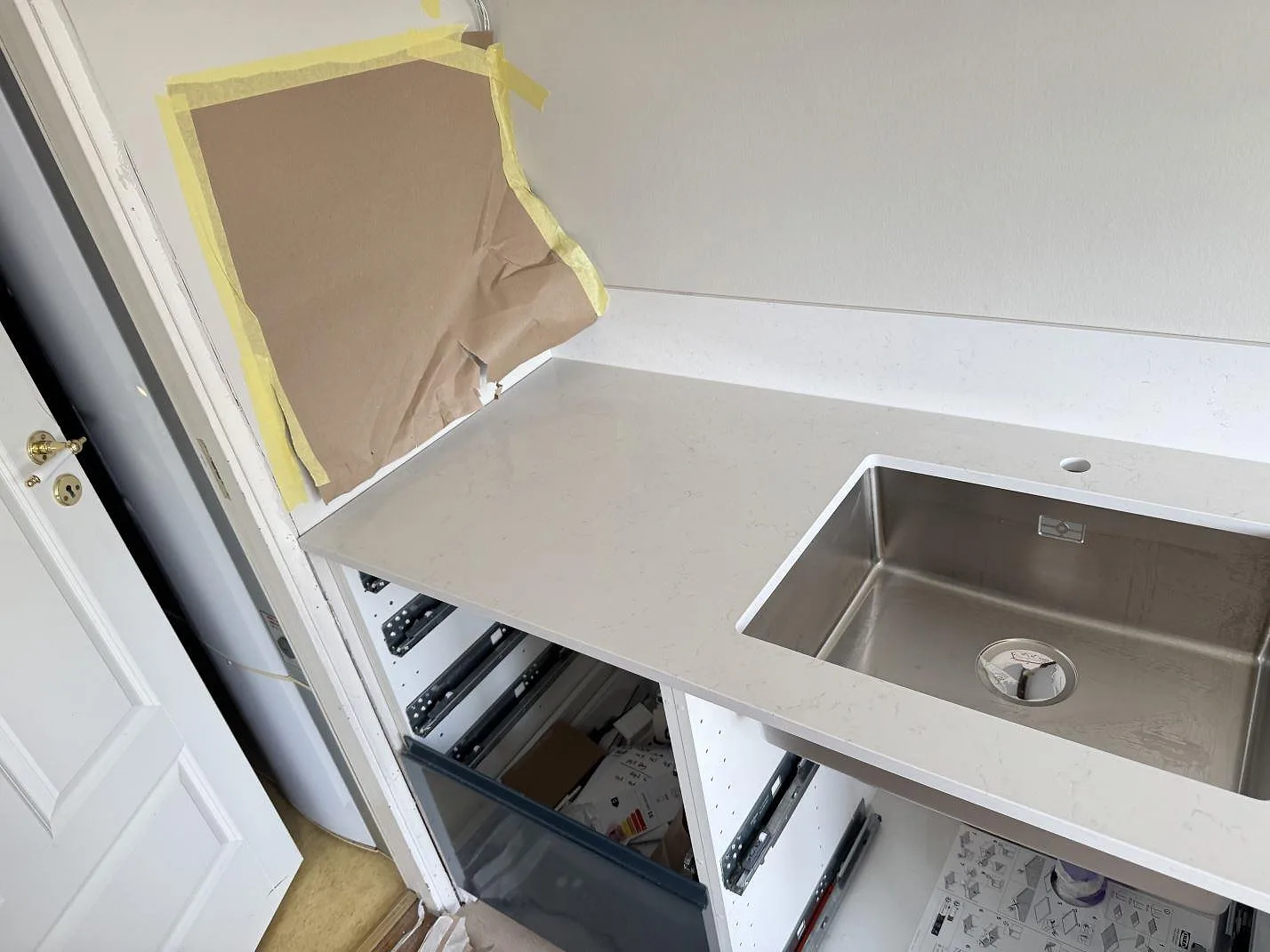 Polerad Silestone Miami Vena runt rostfri diskho och låg stänkkant, fotad under köksmontering i Staffanstorp.