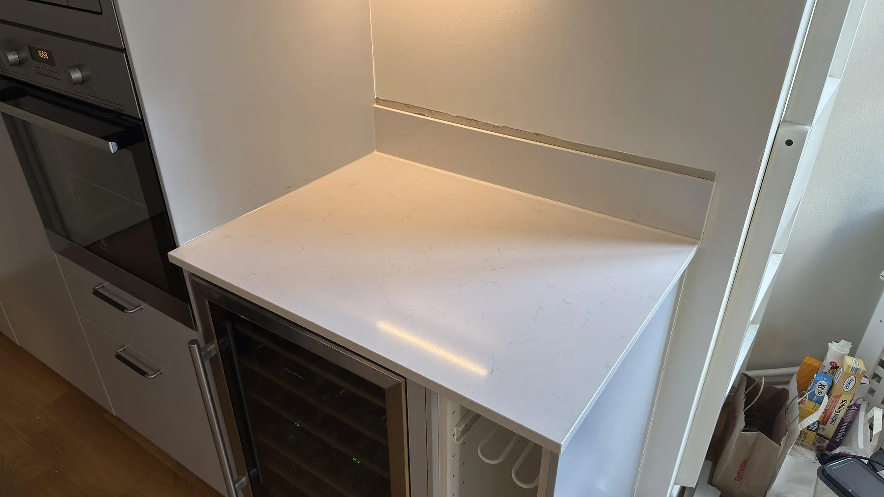 Närbild på den polerade ytan och den grå ådringen i Silestone Miami Vena med urtagning för häll i ett kök i Stockholm.