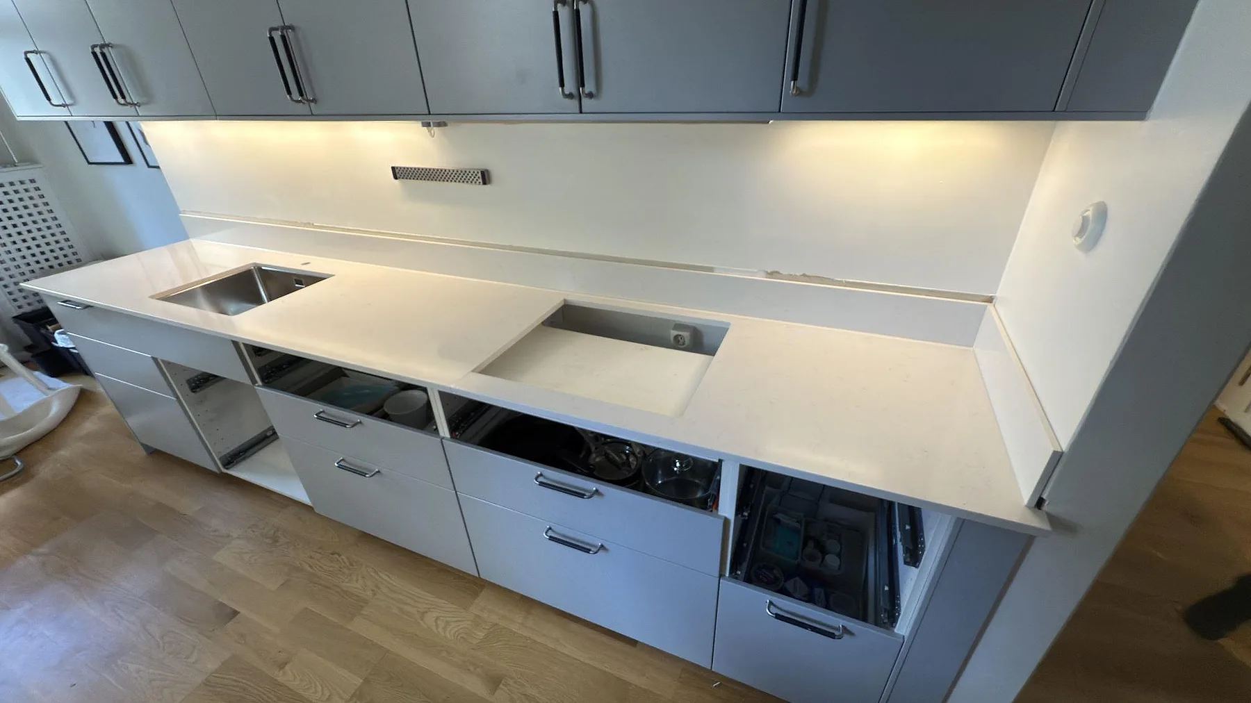 Lång köksbänk i Silestone Miami Vena med underlimmad diskho och förberedd urtagning för häll, fotad under montering i Stockholm.