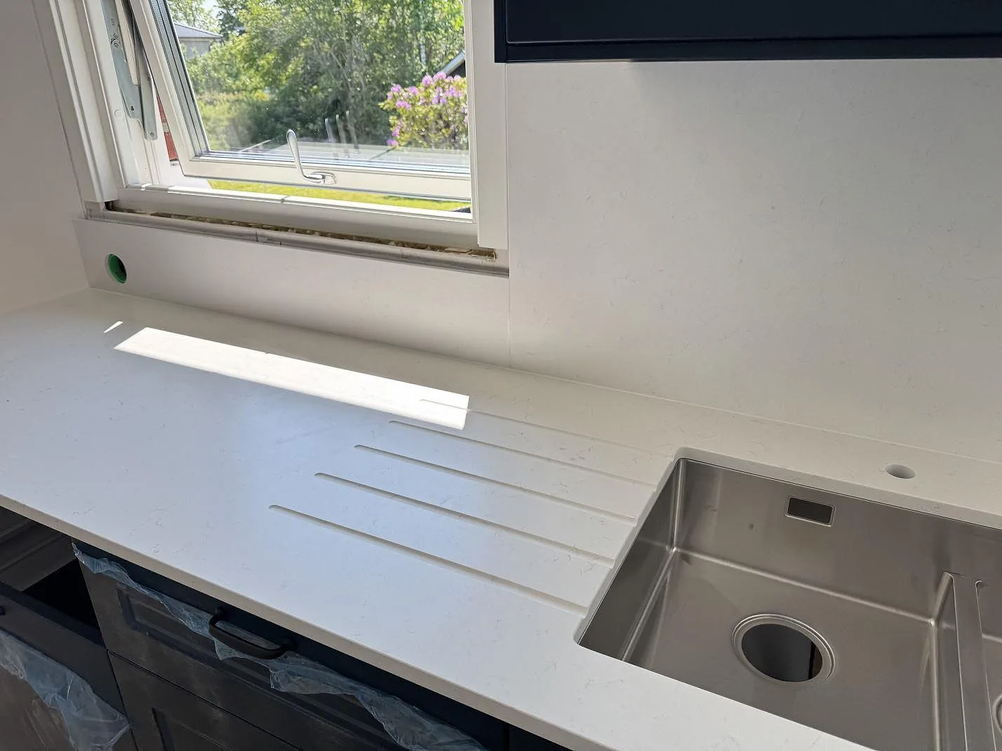 Köksbänkskiva i Silestone Miami Vena, matt kvartskomposit, med rostfri diskho och avrinningsspår i ett kök i Vara.