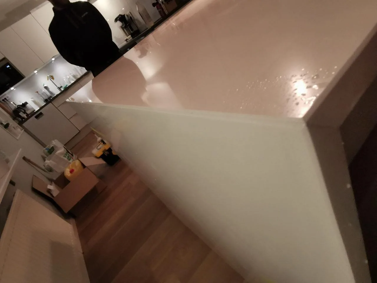 Närbild ovanifrån på den polerade ytan i vit Silestone Miami White med fin grå spräcklighet i ett kök i Häljarp.