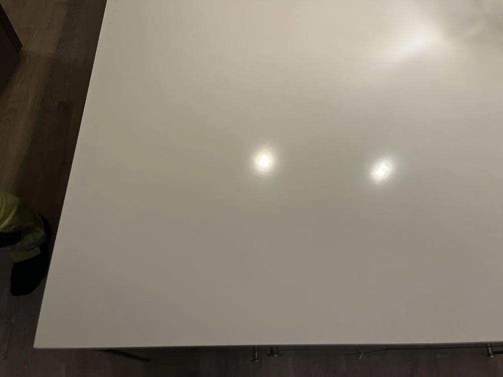 Närbild ovanifrån på polerad vit Silestone Miami White bänkskiva som visar den fina grå spräckligheten i ett kök i Jönköping.