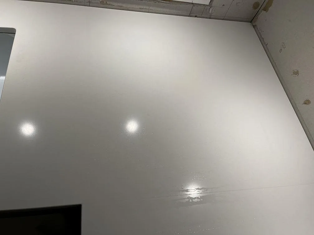 Ovanifrån av polerad vit Silestone Miami White köksbänkskiva med fin grå spräcklighet i ett kök i Jönköping.