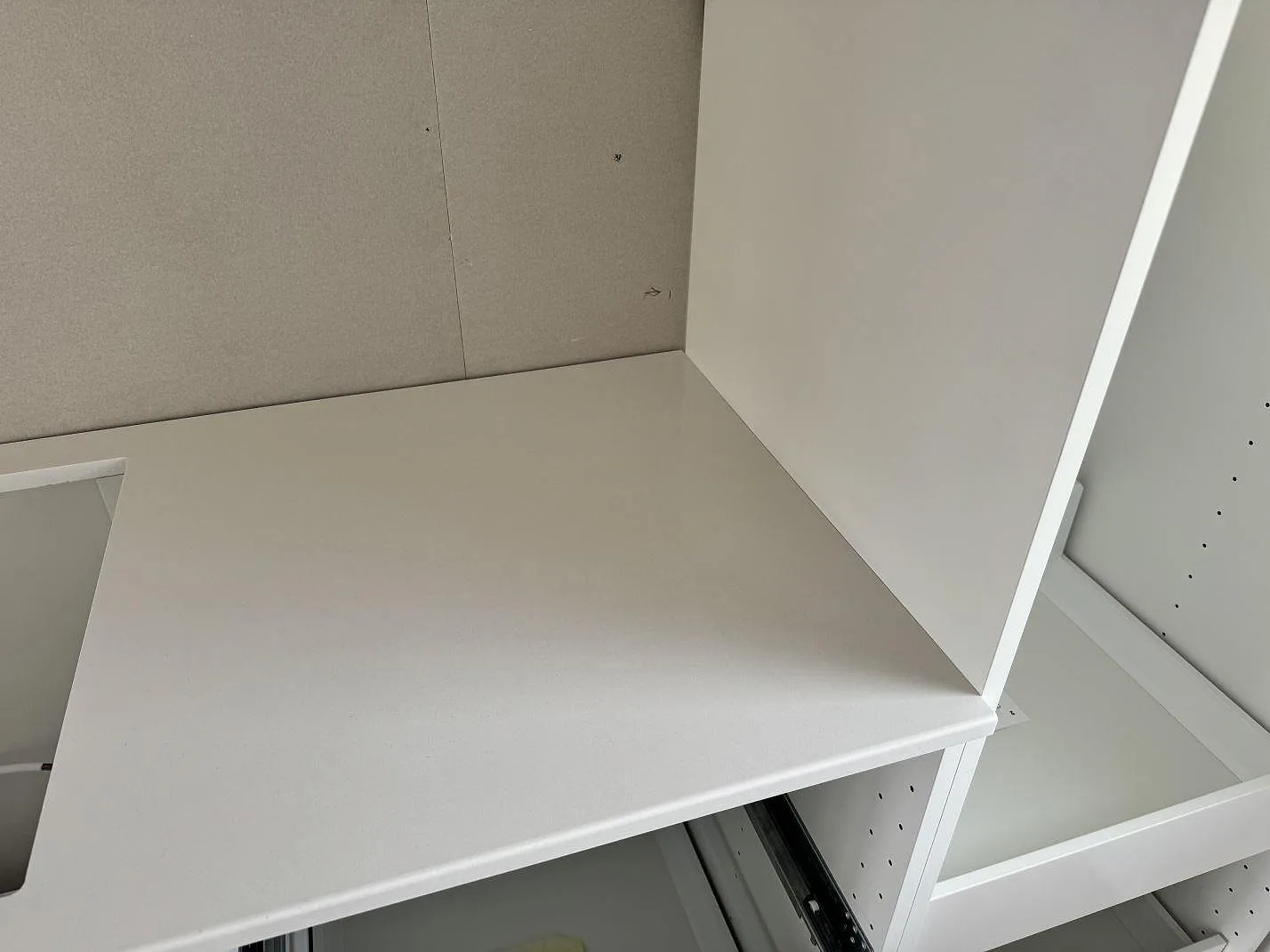 Detalj av vit Silestone Miami White som bänkskiva vid hörn och öppna köksstommar under montering i Jönköping.