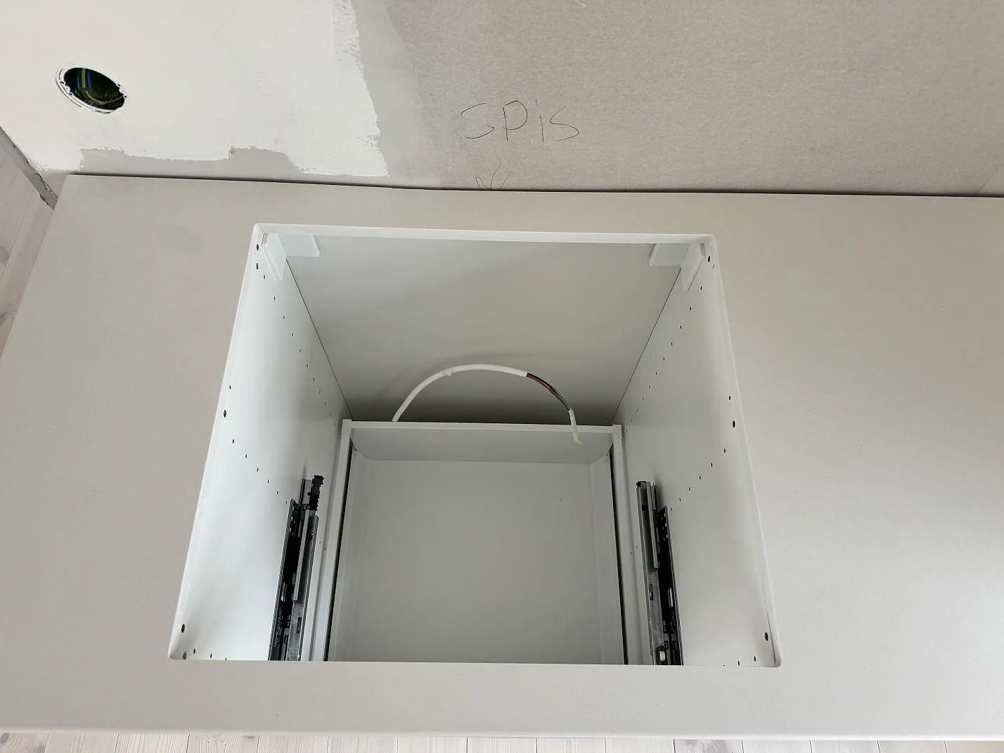 Polerad bänkskiva i Silestone Miami White runt spisområdet, monterad på vita köksstommar i Jönköping.