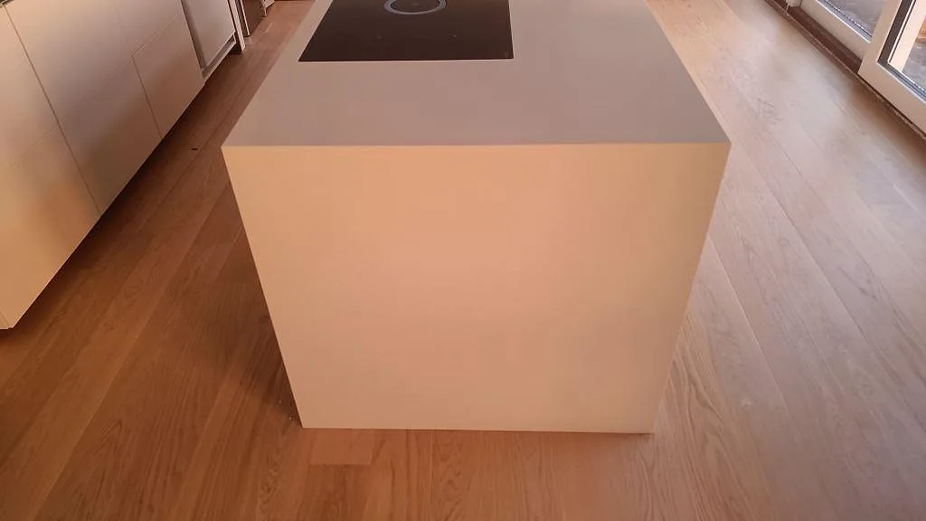 Köksö i Silestone Miami White med släta vita gavlar och nedsänkt greppurtag i ett kök under montering i Karlslunde.