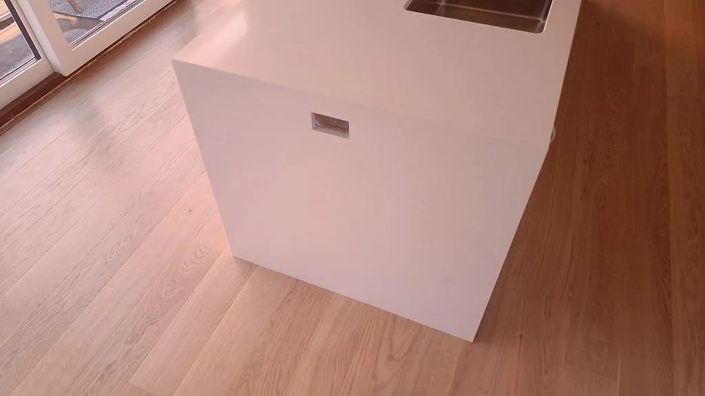 Detalj av underlimmad rostfri diskho i polerad Silestone Miami White köksbänkskiva i Karlslunde.