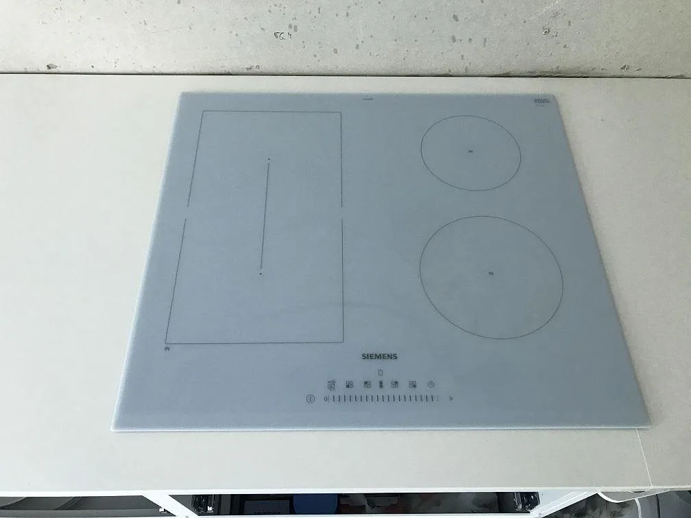 Induktionshäll infälld i en vit Silestone Miami White köksbänkskiva i kvartskomposit i ett kök i Kungälv.
