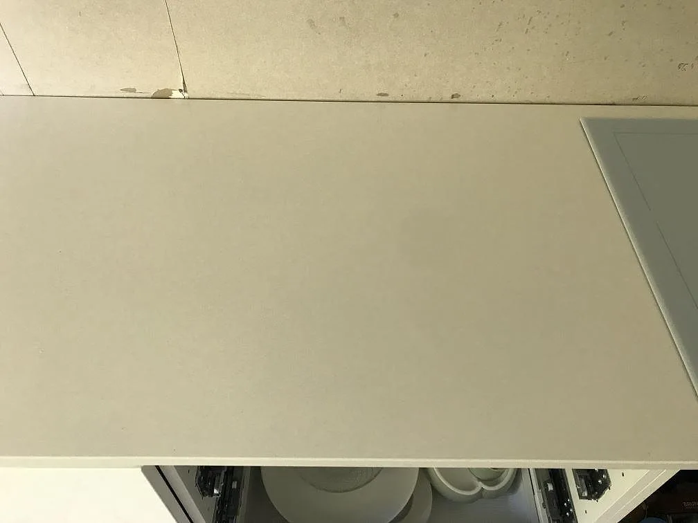 Lång vit köksbänkskiva i polerad Silestone Miami White kvartskomposit i ett kök i Kungälv.