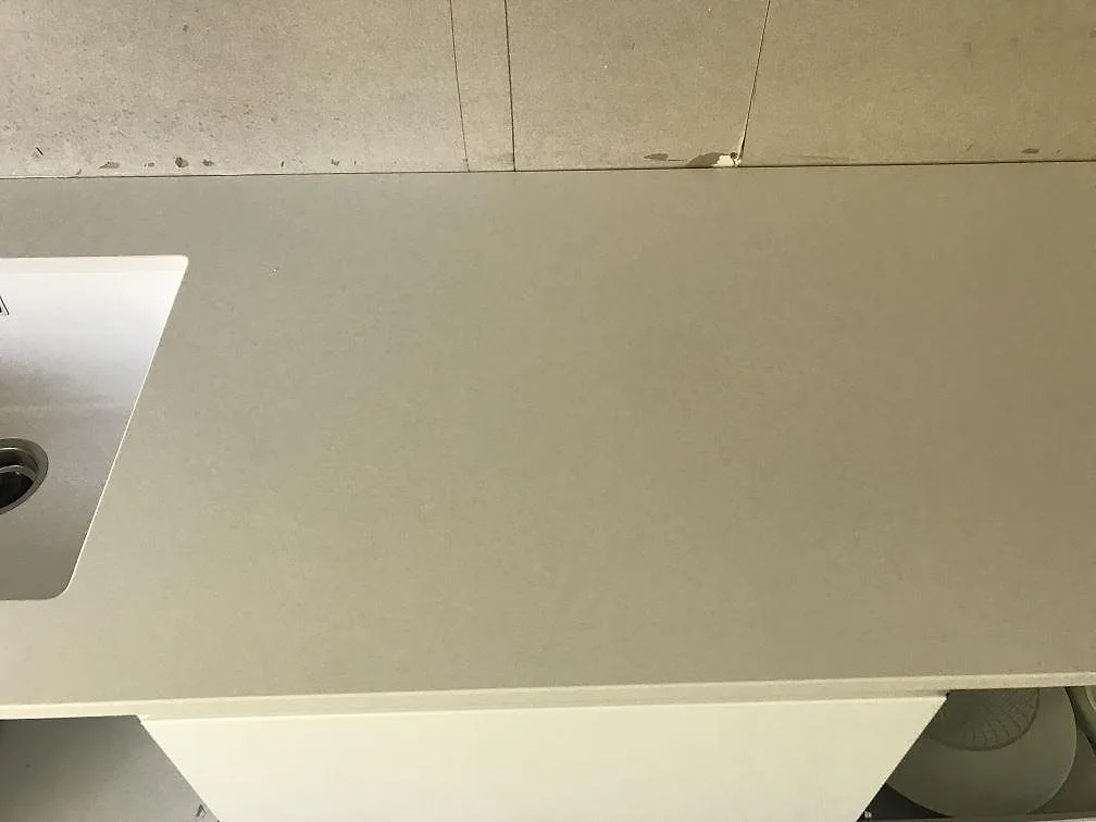 Slät vit Silestone Miami White köksbänkskiva med underlimmad diskho vid kanten i ett kök i Kungälv.