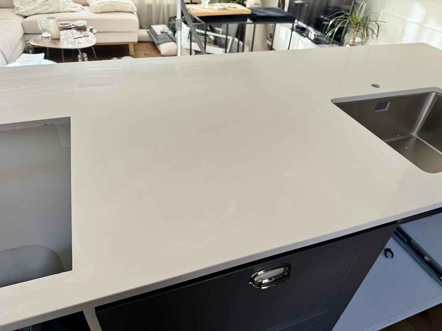 Vit köksbänkskiva i polerad Silestone Miami White komposit med diskho och matplats i bakgrunden i Kungälv.