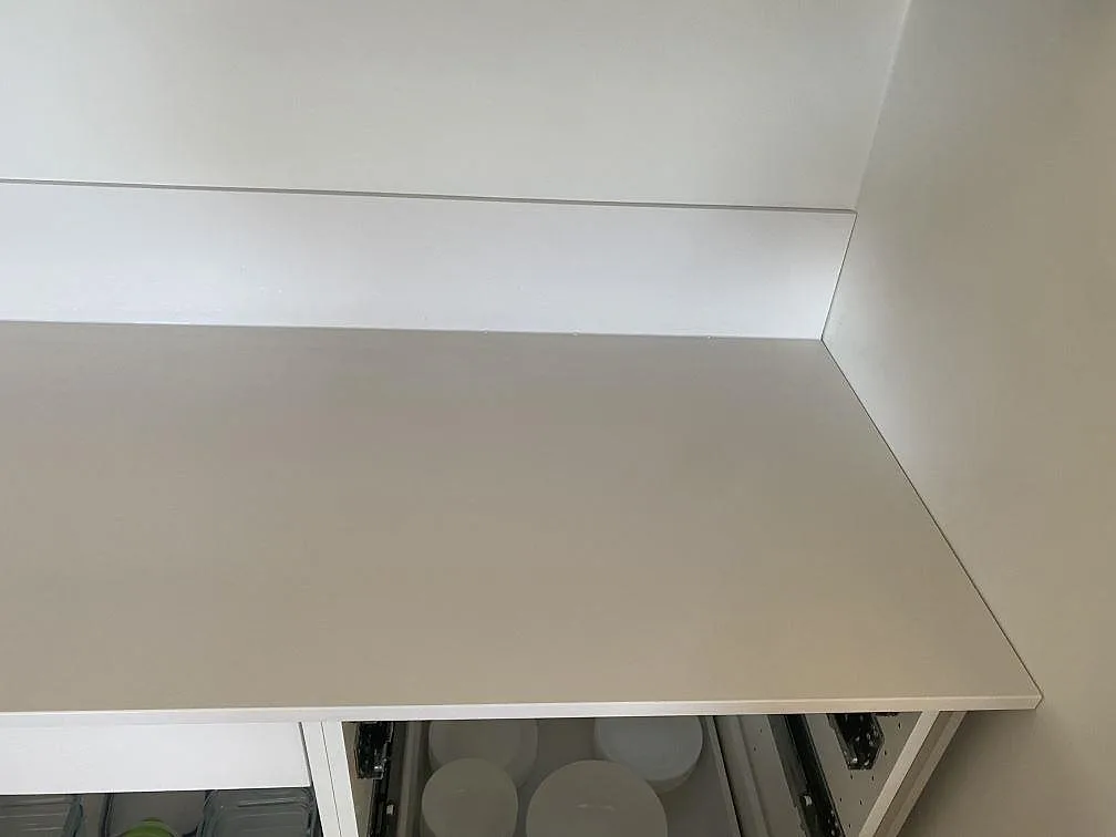 Ren ovanvy av polerad köksbänkskiva i vit Silestone Miami White med fin grå spräcklighet i ett kök i Påarp.
