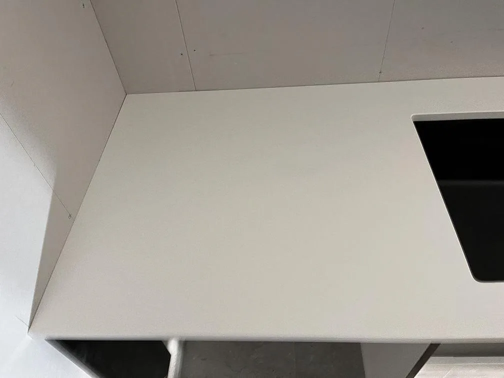 Vit Silestone Miami White bänkskiva som viker runt ett hörn med urtag för underlimmad diskho i ett kök i Rockneby.