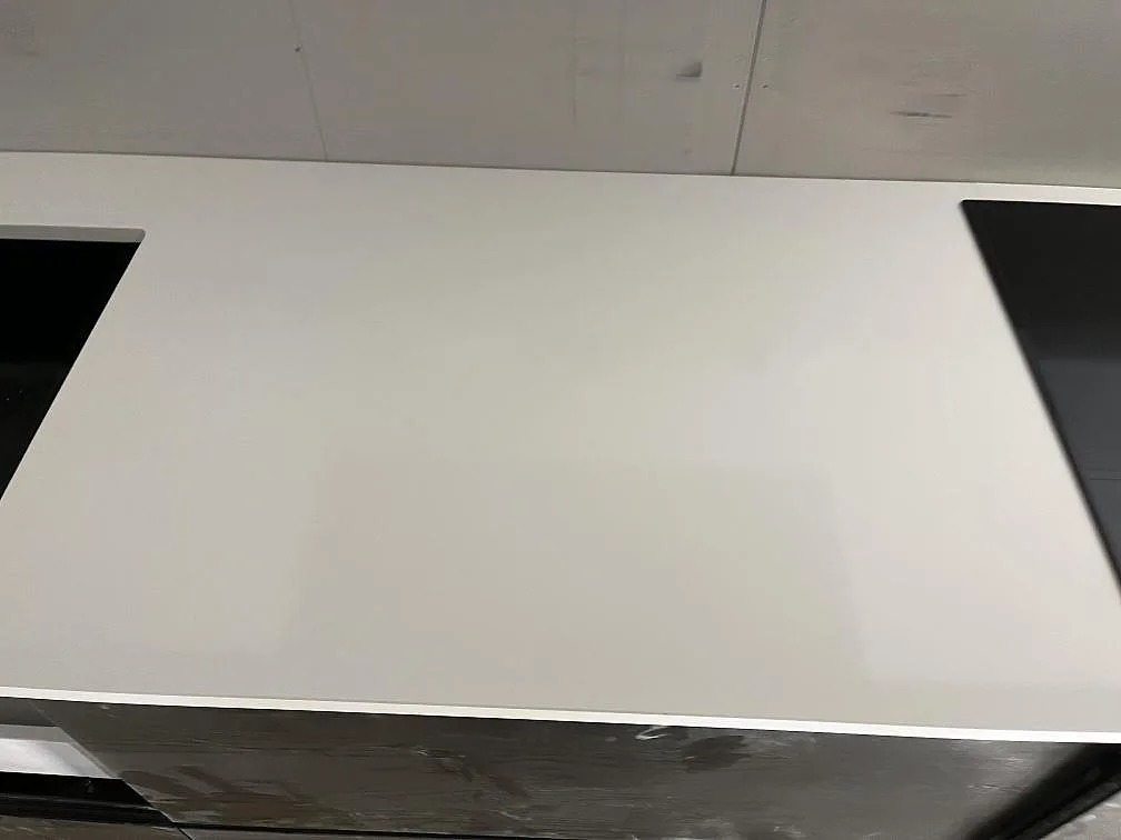 Vit Silestone Miami White köksbänkskiva monterad mellan diskho och induktionshäll i ett kök under montering i Rockneby.