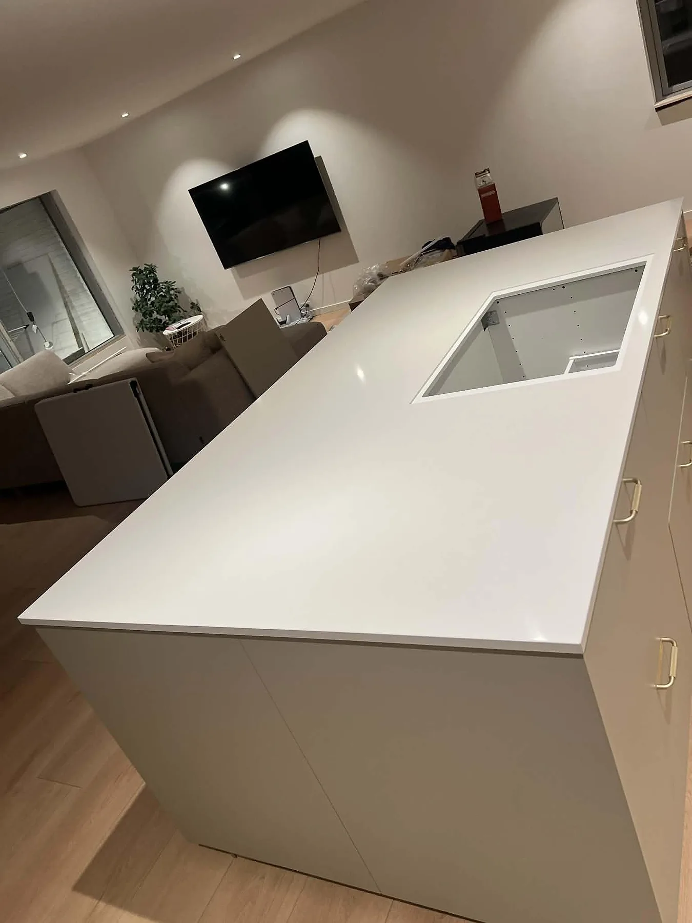Köksö i vit Silestone Miami White, polerad 20 mm med diskret grå ådring och förberett hällurtag, i ett öppet kök i Smørum.