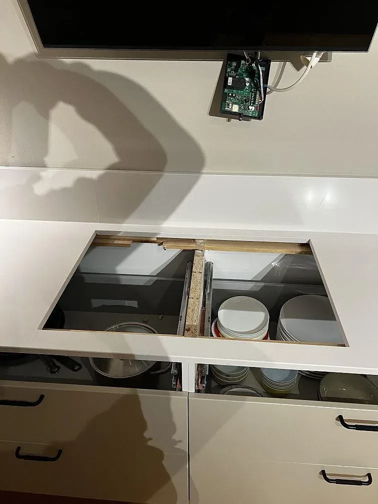 Polerad Silestone Miami White med öppna köksfronter, låg stänkkant och mörka detaljer i ett kök i Trelleborg under montering.