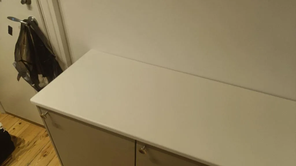 Rak sidobänk i polerad Silestone Miami White monterad mot vägg i ett kompakt kök i Valby.