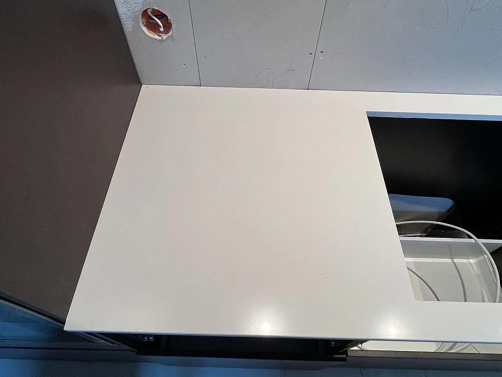 Top-down av polerad vit Silestone Miami White köksbänkskiva under montering i ett kök i Varberg.