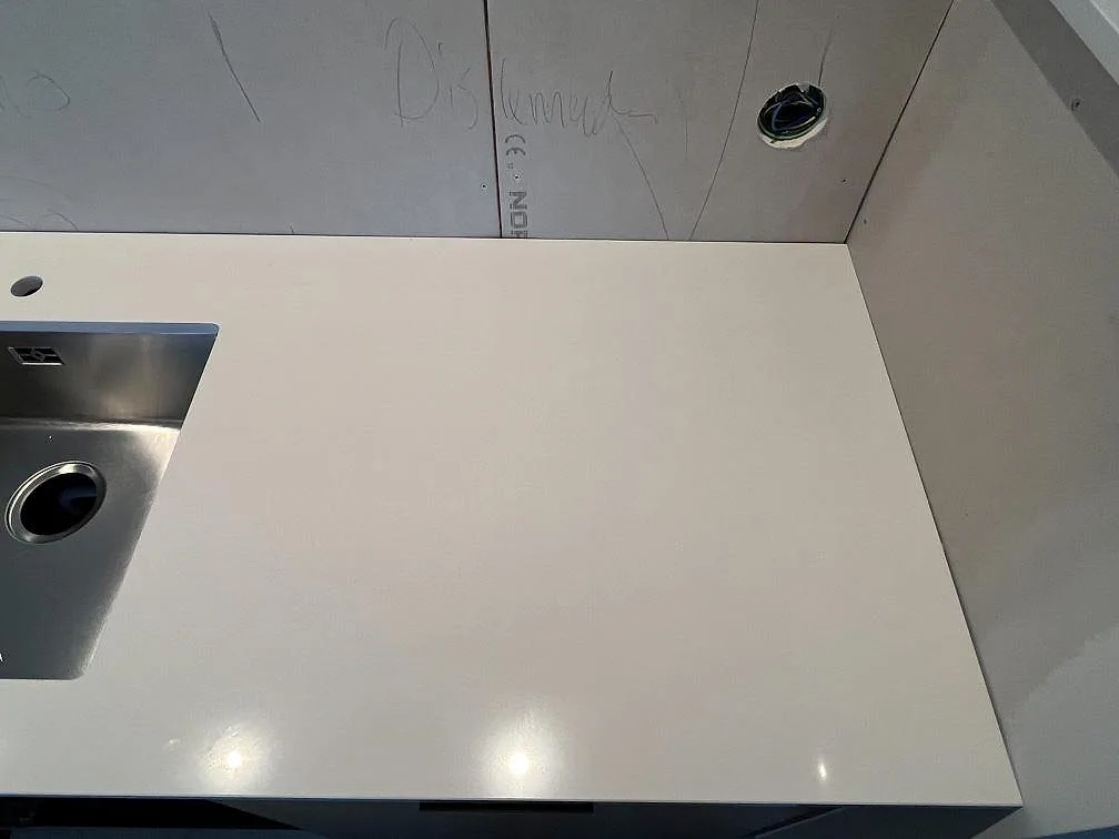 Köksbänk i vit Silestone Miami White, polerad, med hörn av underlimmad rostfri diskho i Varberg.