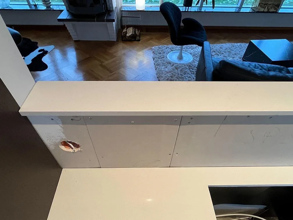 Köksbänkskiva i vit Silestone Miami White, polerad, på en lång bardel i ett kök under montering i Varberg.
