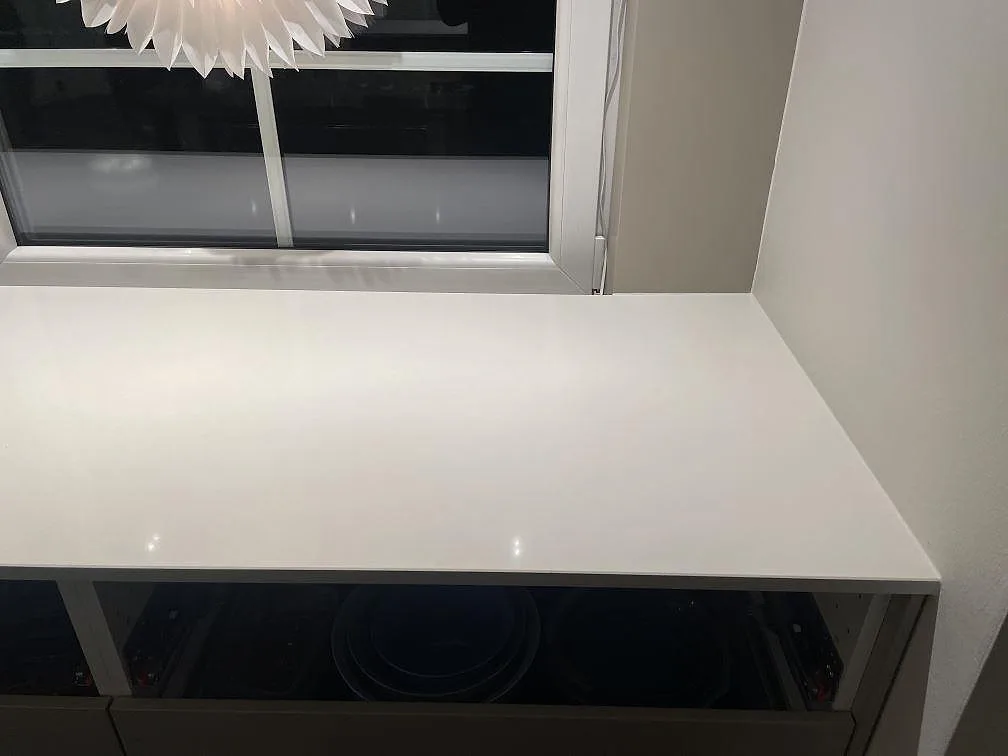 Köksbänkskiva i vit Silestone Miami White vid fönstret, mitt under montering i Vejbystrand