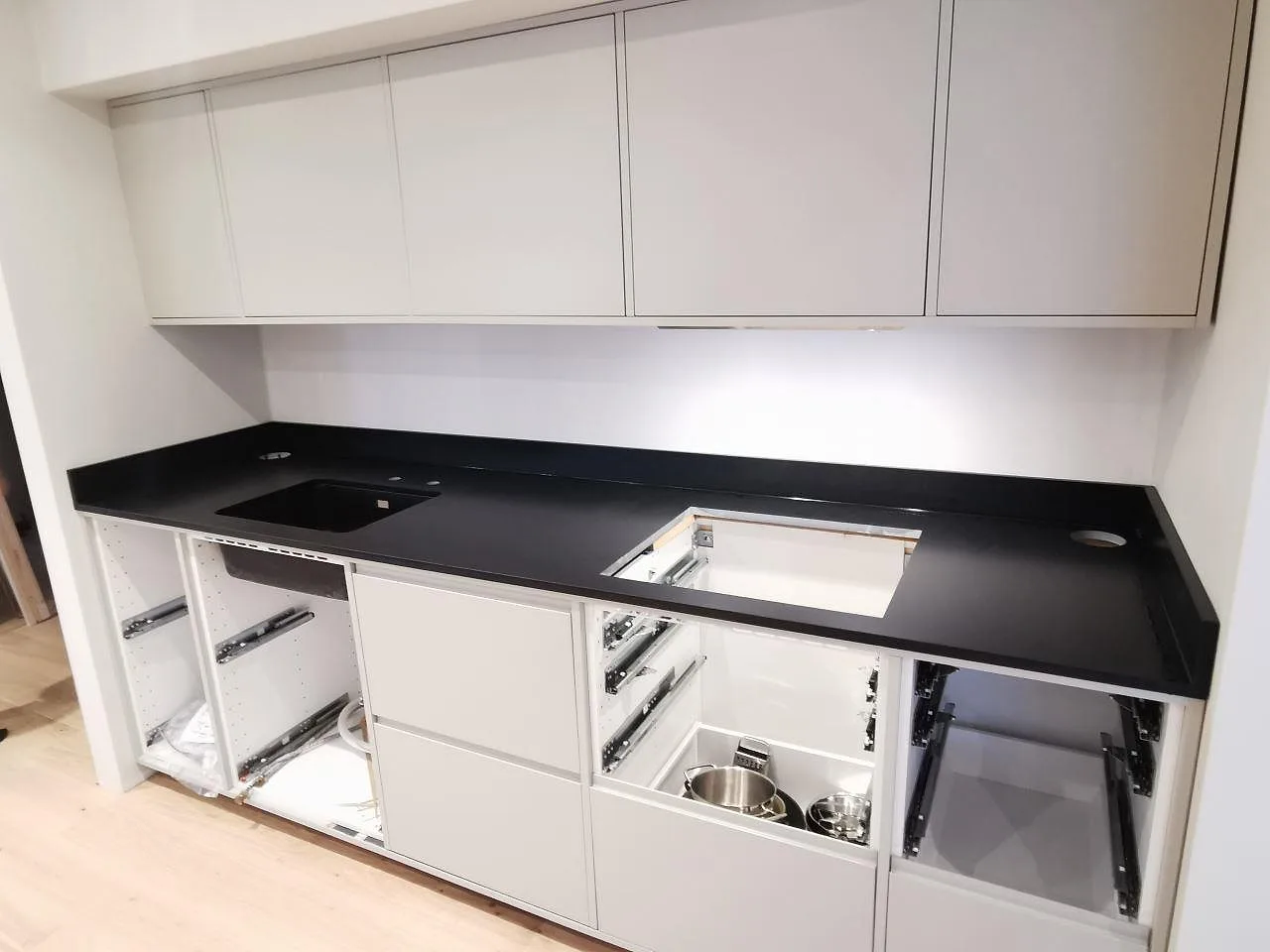Köksbänkskiva i svart Silestone Negro Tebas, matt Mocka-yta, med underlimmad svart diskho och hälluttag i ett kök i Höllviken.