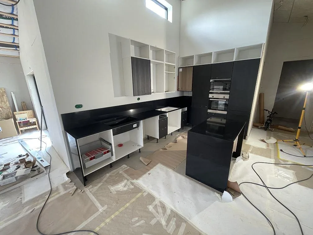 Köksbänkskiva i mörk Silestone Night Tebas, polerad högglans, med köksö och bänkrad mot vägg i ett kök under montering i Skövde.