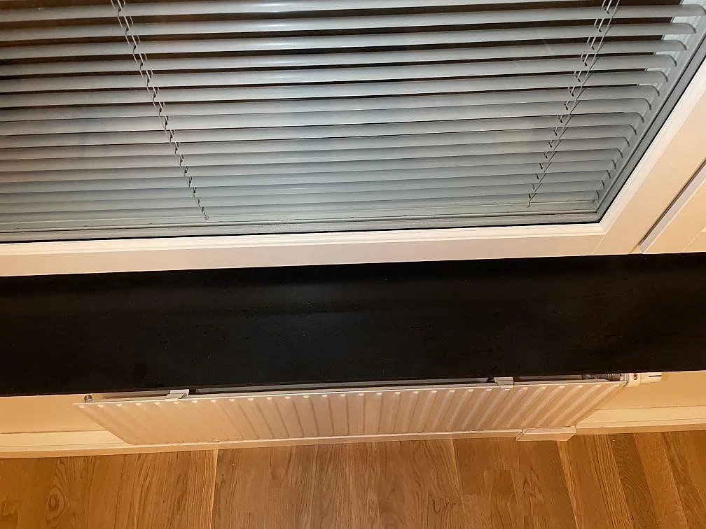 Närbild av fönsterbänk i svart Silestone Night Tebas, matt kvartskomposit med rak framkant i Stockholm.